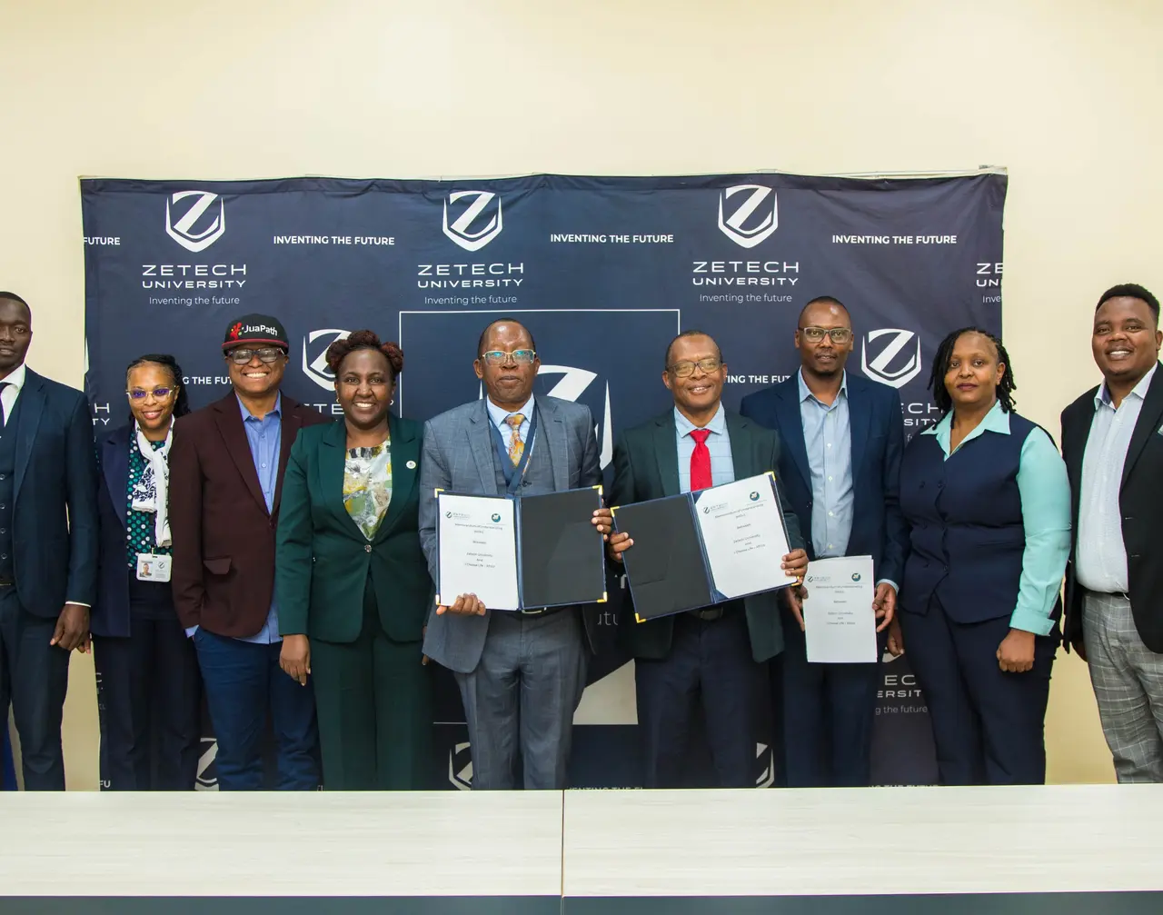 Leaders from I Choose Life – Africa, Zetech University and JuaPath gather together after the MoU signing, including Victor Sila in a red JuaPath cap.